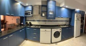 a kitchen with blue cabinets and a washing machine at Casa Rava in Santiago del Estero