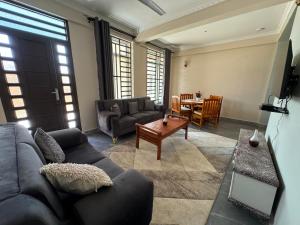 uma sala de estar com um sofá e uma mesa em Suji House em Dodoma