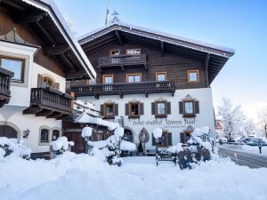 a building covered in snow with snow around it at Alpen Glück Hotel Unterm Rain garni in Kirchberg in Tirol