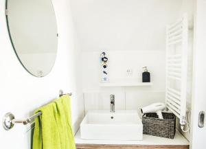 a white bathroom with a sink and a mirror at Perlekieker 2 in Büsum