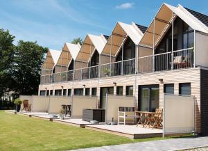 a building with balconies and a table and chairs at Perlekieker 2 in Büsum