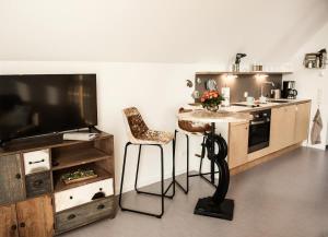 a kitchen with a counter and a table and a television at Achtern Diek in Büsum +9 photos