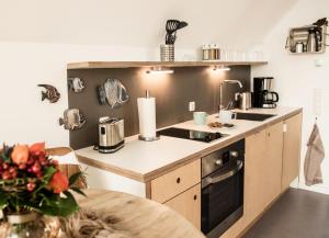 a kitchen with a counter with a stove top oven at Achtern Diek in Büsum