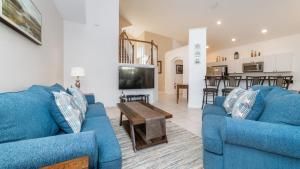 sala de estar con 2 sofás azules y TV en 6 BR Vacation Home for 12 Guests, en Kissimmee