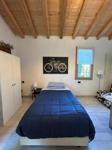 Un dormitorio con una gran cama azul con una foto de una motocicleta en CASETTO ROSSO, en San Lazzaro di Savena