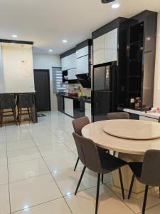 cocina y comedor con mesa y sillas en UG Homestay BP - Netflix & 4 Air-Con Rooms, en Batu Pahat