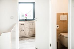 uma casa de banho com um WC e uma janela em Strandnest em Büsum