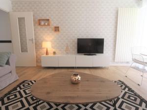 a living room with a table and a tv at Bénodet : Superbe T2 rénové à 100m de la plage, parking inclus - FR-1-481-90 in Bénodet