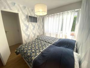 a bedroom with a bed and a large window at Bénodet : Superbe T2 rénové à 100m de la plage, parking inclus - FR-1-481-90 in Bénodet