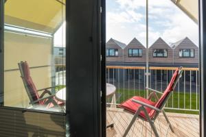 two chairs sitting on a balcony with a view of a building at Steife Brise in Büsum