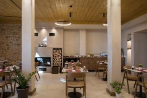 a restaurant with tables and chairs and a kitchen at Μikri Arktos Boutique Hotel in Dhimitsana