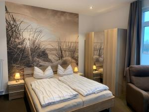 a bedroom with a bed with a painting on the wall at Pension Haus Beckmann in Borkum