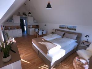 a bedroom with a large bed and a kitchen at Sandbank in Büsum