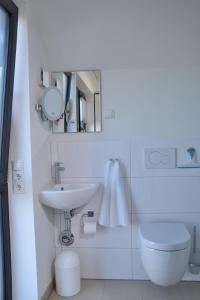 a bathroom with a sink and a toilet and a mirror at Sandbank in Büsum