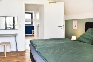 een slaapkamer met een bed, een tafel en een stoel bij Haus Deichkind in Büsum