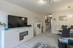 a living room with a flat screen tv and a fireplace at Ankerplatz in Büsum