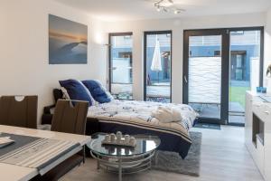 a bedroom with a bed and a table and a kitchen at Ankerplatz in Büsum