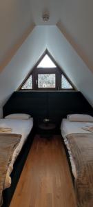 a attic room with two beds and a window at Vila Irina Kopaonik in Kopaonik +137 photos