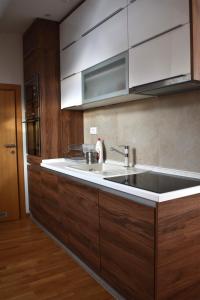 a kitchen with a large sink and wooden cabinets at Vila Irina Kopaonik in Kopaonik +139 photos