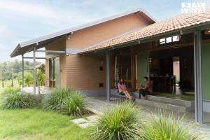 two people sitting on the porch of a house at StayVista at Sunnyside Homestay with Bonfire & Lawn in Honnekere +18 photos