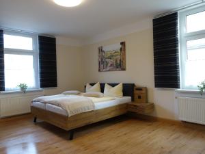 Apartment-Haus Am Jakobsweg في بوتسن: غرفة نوم بسرير ونوافذ