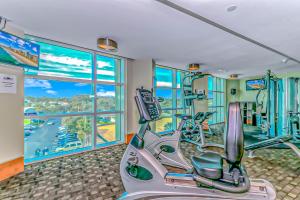 einen Fitnessraum mit Kardiogeräten und einem großen Fenster in der Unterkunft Sandy Beach 1612 in Myrtle Beach
