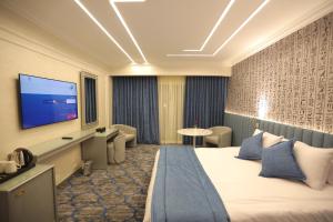 a hotel room with a bed and a flat screen tv at Pyramids Park Resort Cairo in Cairo