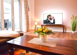 a living room with a vase of flowers on a coffee table at Appartement Abendsonne in Büsum