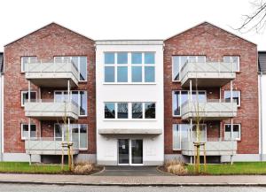 um edifício de tijolos vermelhos com duas varandas em Appartement Abendsonne em Büsum