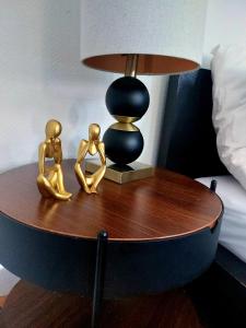 a table with two gold figurines on it next to a lamp at Central and calm appartement in Aachen in Aachen