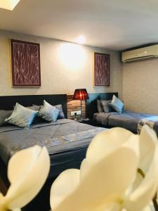 une chambre d'hôtel avec deux lits et un canapé dans l'établissement FirIzzkey Studio, à Kota Bharu