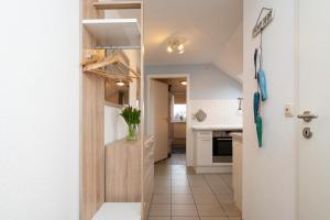 a kitchen with white walls and a door with a vase on it at Elbe1 in Büsum