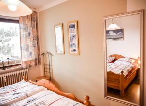 ein Schlafzimmer mit einem Spiegel neben einem Bett in der Unterkunft Muschelbank in Büsum