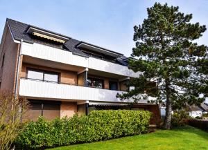 ein Gebäude mit einem Baum davor in der Unterkunft Muschelbank in Büsum