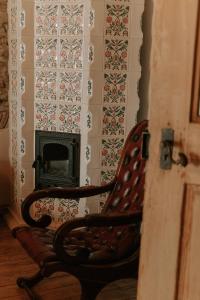 a wooden chair sitting in front of a fireplace at Fronius Boutique Residence in Sighişoara