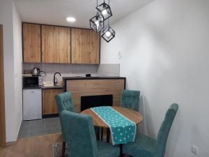 a kitchen with a table and chairs and a kitchen with a stove at Stan na dan - Apartman Blue Moon in Lukavica