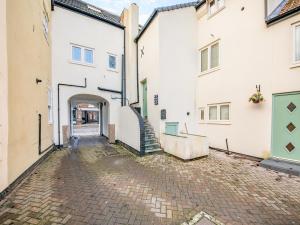 an alleyway between two white buildings with a staircase at Blossom Apartment - Uk45970 in Yarm
