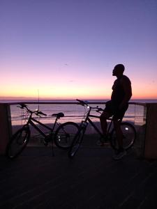 ブリドリントンにあるHome and Away Guesthouseの海岸で自転車に乗っている男