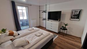 a bedroom with two beds and a flat screen tv at WARTEN - Lake Lodge in Bregenz