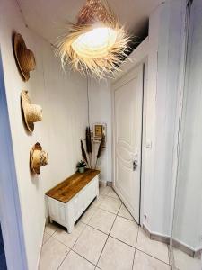 un pasillo con una gran lámpara de araña y una puerta blanca en Jolie maison de 40m2 avec jardin, en Boissy-Saint-Léger