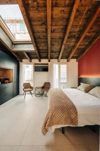 a bedroom with a large bed with a wooden ceiling at Casa Pelegrí in Morella