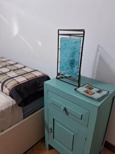 - une table de chevet bleue avec un miroir à côté d'un lit dans l'établissement RIO lodge, à San Nicolás de los Arroyos