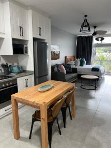 cocina y sala de estar con mesa de madera en Beachfront Umdloti Resort 303, en Umdloti