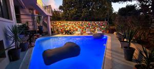 una piscina en un patio con sillas y una valla en African Groove Camps Bay, en Ciudad del Cabo