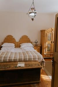 een slaapkamer met een groot bed met een houten hoofdeinde bij Fronius Boutique Residence in Sighişoara
