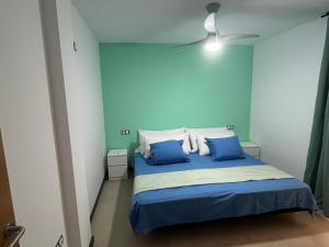 1 dormitorio con paredes azules y 1 cama con almohadas azules en Casa Teri - La Concha, en Cotillo