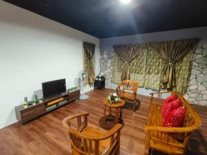 ein Wohnzimmer mit Stühlen und einem Flachbild-TV in der Unterkunft 1 Hati Homestay Sepang in Sepang