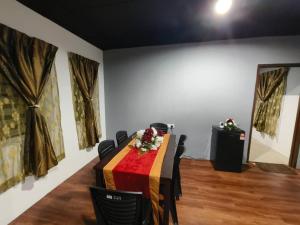 a conference room with a table and chairs and paintings at 1 Hati Homestay Sepang in Sepang