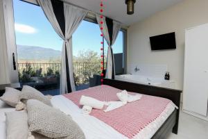 サンタ・マリア・デ・パラウトルデーラにあるLes Suitesのベッドルーム1室(ベッド1台、バスタブ、窓付)