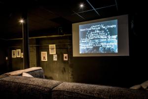 um sofá num quarto com um ecrã de projecção em Villa Avril & spa, cinema, sauna & piscine - 15 Pers-proche Europapark em Sélestat